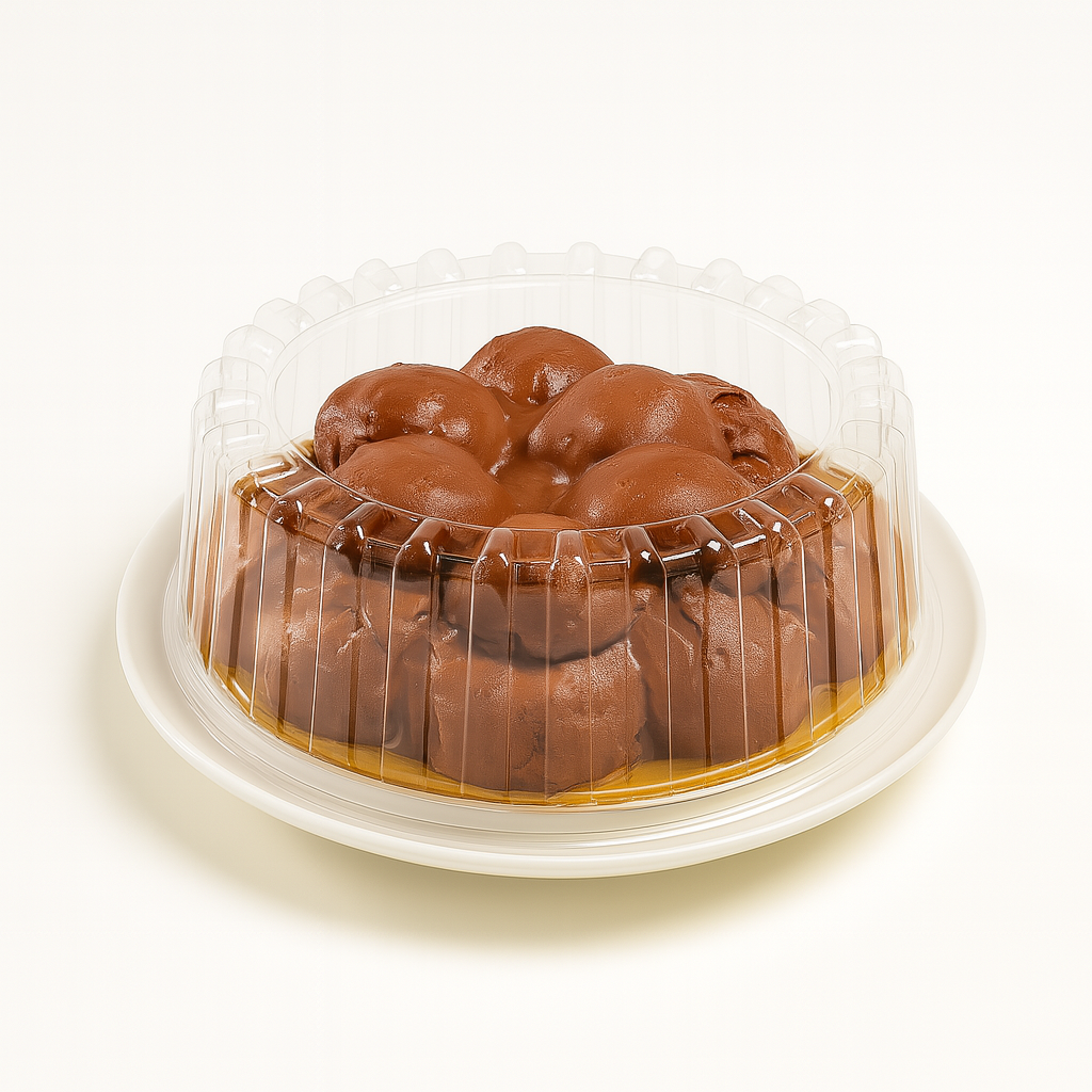 A braided chocolate bread enclosed in a clear, ribbed plastic dome container, sitting on a white plate against a neutral cream background.