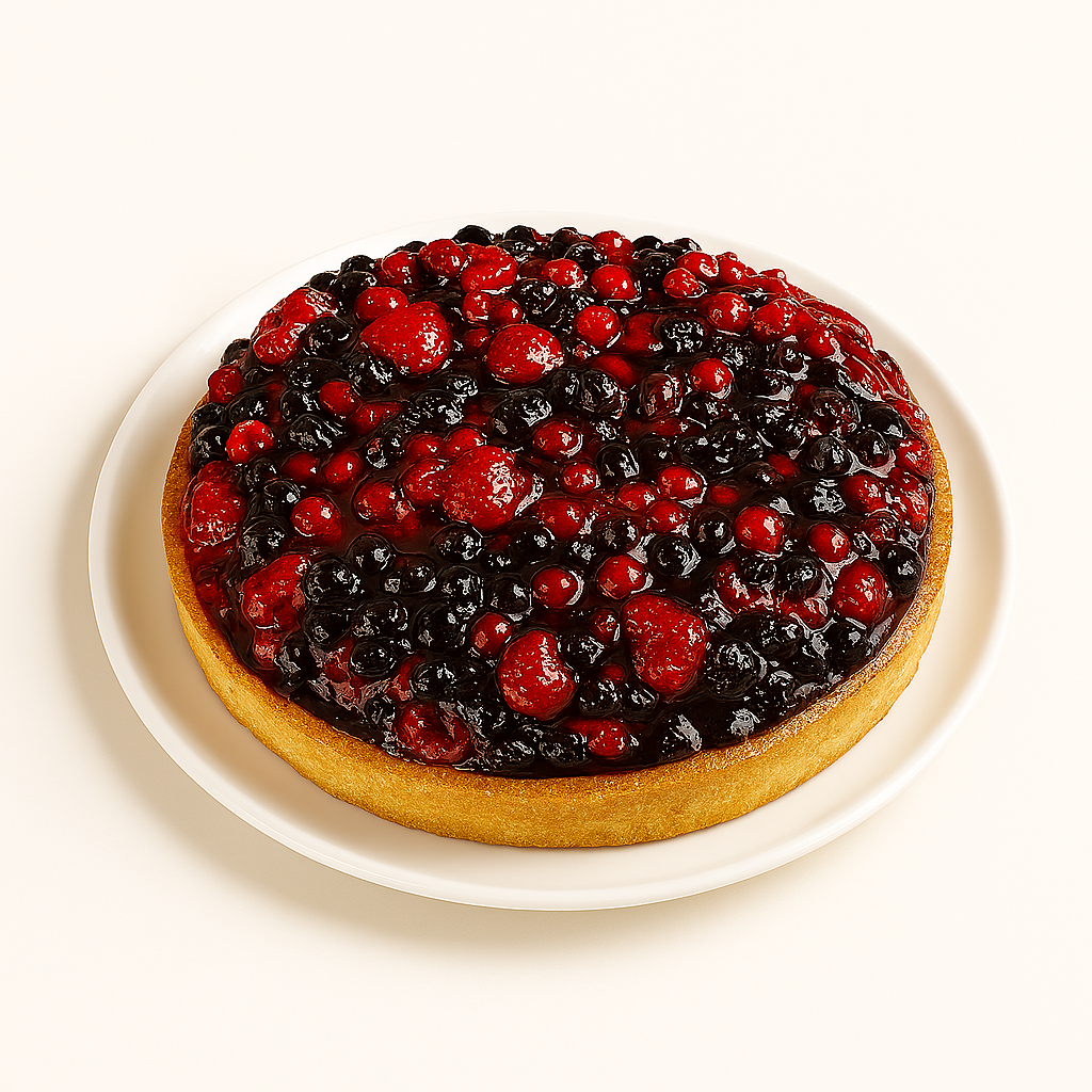 A round wild berry tart sits on a white plate against a plain white background. The tart is topped generously with glossy red and dark berries, including strawberries, raspberries, and blueberries, creating a vibrant, colorful surface. The golden-brown crust contrasts with the bright berry topping.