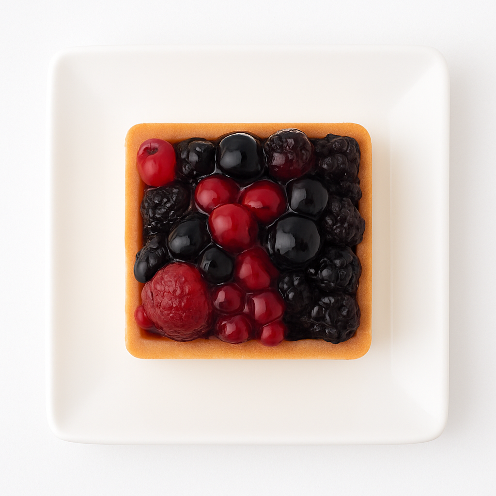 Top-down view of a square fruit tart on a white square plate. The tart is neatly filled with an arrangement of mixed berries—raspberries, blackberries, blueberries, and red currants—glistening under a light glaze. The image showcases the geometric shape and colorful fruit pattern.