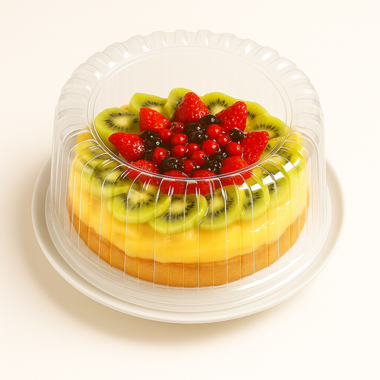 A round fruit tart inside a clear plastic dome container, sitting on a white plate against a white background. The tart has a bright yellow custard filling, topped with rings of fresh kiwi slices and a center of glossy strawberries and mixed red and black berries.