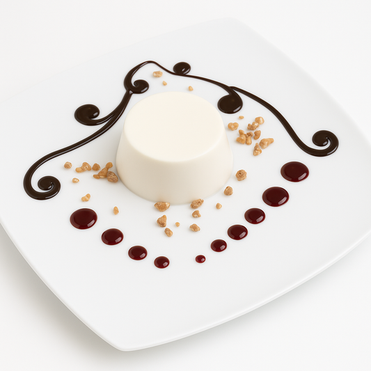 Elegant panna cotta served on a white square plate, decorated with chocolate swirls, red fruit sauce dots, and crunchy caramel crumbs.